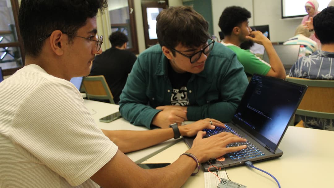 Students programming an Arduino board.